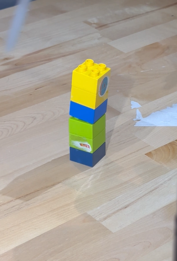 The first manual stack: the yellow and blue assembly sits on the green and dark blue one, aligned but not pressed fully down