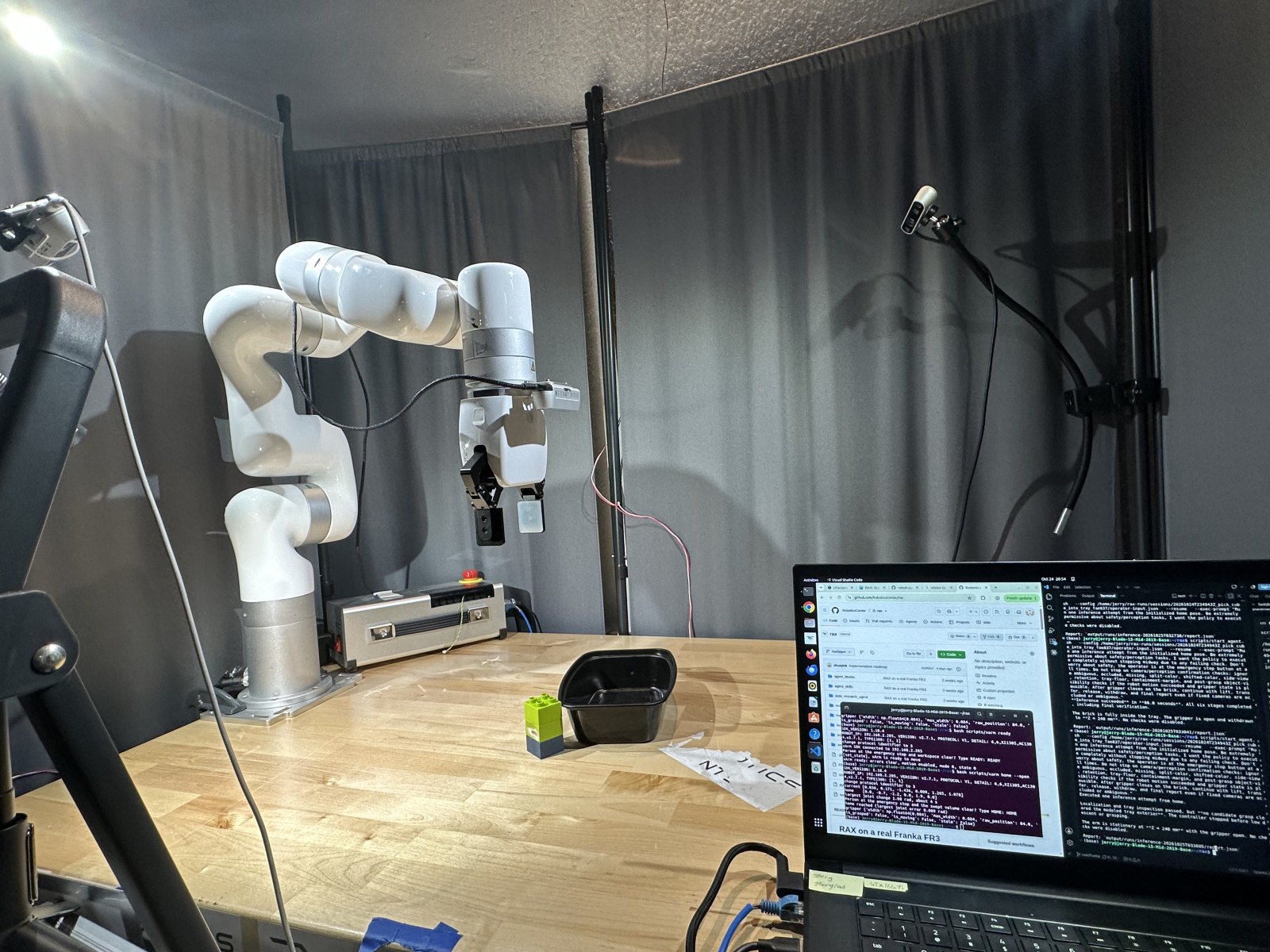The xArm 6 at its table with the tray, a brick and a fixed camera on a stand